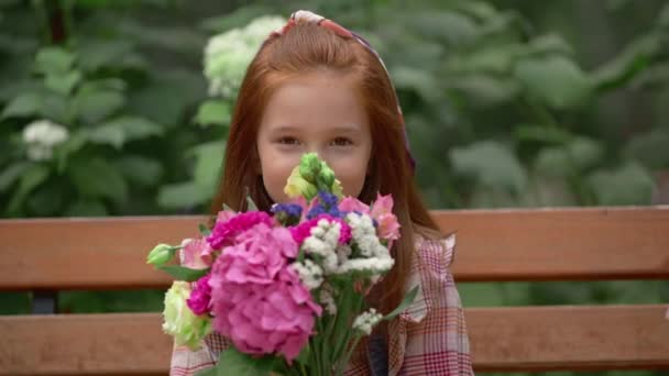 Αξιολάτρευτο Χαμογελαστή Παιδί Που Μυρίζει Λουλούδια Στο Πάρκο — Αρχείο Βίντεο