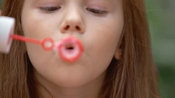 愛らしい子供が石鹸の泡を吹くクローズアップビュー — ストック動画