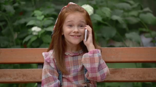 快乐可爱的孩子在公园里谈论智能手机 — 图库视频影像