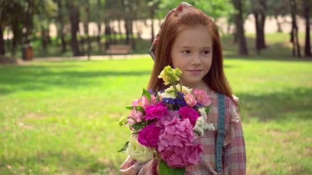 Ευτυχισμένο Κοκκινομάλλα Παιδί Μυρωδιά Λουλούδια Πράσινο Πάρκο — Αρχείο Βίντεο