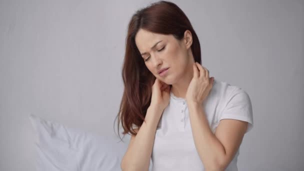 寝室で首の痛みに苦しむ美しい女性 — ストック動画