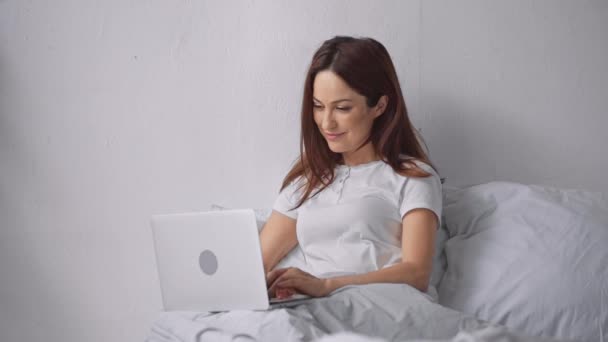 Ευτυχισμένη Γυναίκα Που Χρησιμοποιεί Φορητό Υπολογιστή Στο Κρεβάτι — Αρχείο Βίντεο