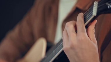 evde akustik gitar çalan adamın kırpılmış görünümü