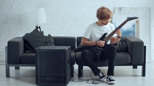 Joven Rockero Tocando Guitarra Eléctrica Sofá Cerca Del Altavoz — Vídeos de Stock