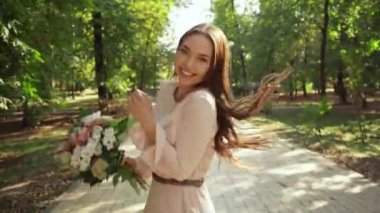 parkta çalışan buket ile mutlu genç kadının arka görünümü