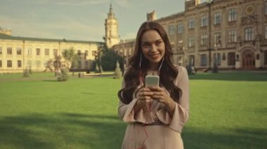 Kiev, Ukrayna - 27 Ağustos 2019: akıllı telefonda dans eden ve müzik dinleyen genç kadın