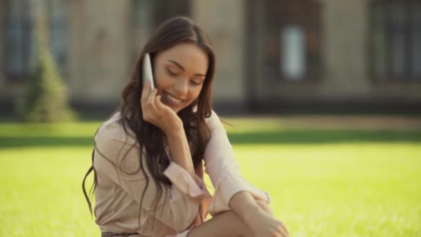 Mujer Joven Hablando Teléfono Inteligente Sentado Hierba — Vídeo de stock