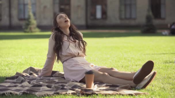 コーヒーの近くに毛布の上に横たわっている若い女性 — ストック動画