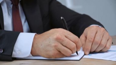 not defterine yazan işadamının kırpılmış görünümü