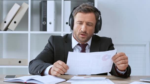 Mature Businessman Working Documents Listening Music Workplace — Stock Video