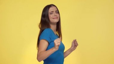 Sarı renkte dans eden mutlu kız.