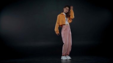 Siyah üzerinde dans eden çekici ve şık bir kadın.
