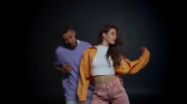 Mutlu Afro-Amerikan erkeği ve stil sahibi kadın siyah üzerinde dans ediyor. 