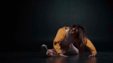 Güzel bir kadın esniyor ve siyah üzerinde dans ediyor 