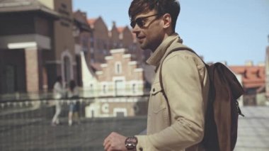 Sırt çantalı mutlu adam dışarıda yürüyor. 