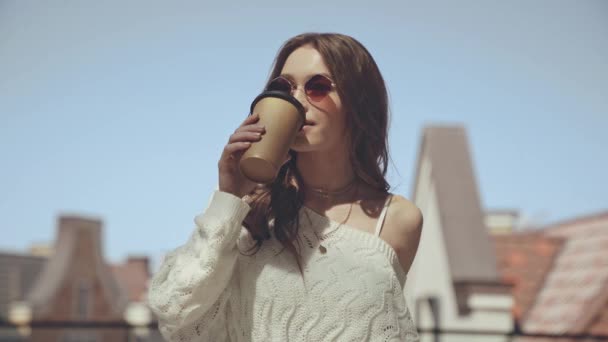 魅力的な女性が歩き使い捨てカップを持ち — ストック動画