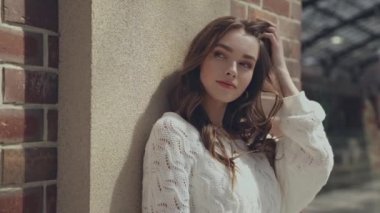 Çekici kız alışveriş çantasıyla dışarıda duruyor. 