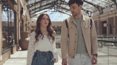 Alışveriş merkezinde kadın ve erkek konuşuyor. 