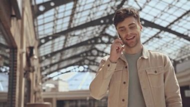 Akıllı telefon kullanırken mutlu adam yürüyor. 