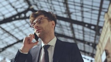 Akıllı telefondan konuşan iş adamının düşük açılı görüntüsü 