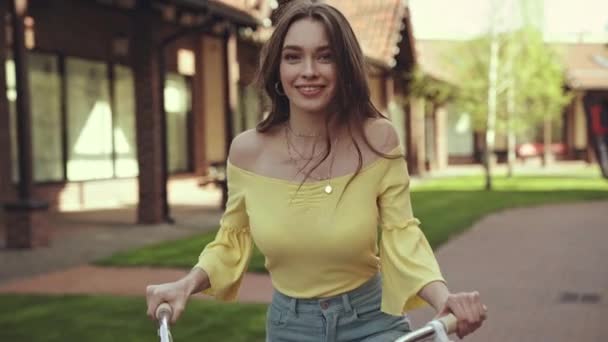 ビルの近くで自転車に乗る陽気な女の子 — ストック動画