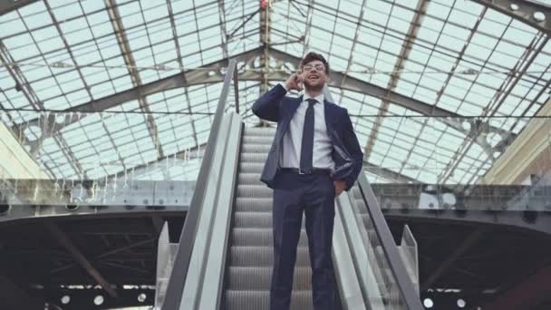 Fröhlicher Geschäftsmann Mit Smartphone Auf Rolltreppe — Stockvideo