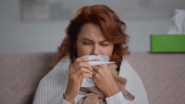 Hasta kadının odak noktası termometreye ve hapşırmaya bakıyor.