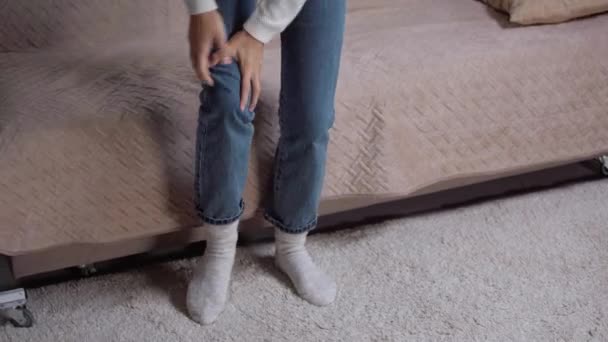 年轻女子从沙发上站起来感到膝盖酸痛 — 图库视频影像