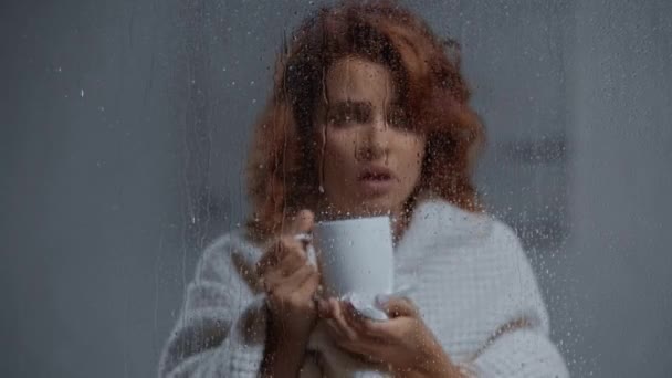 Sick Woman Drinking Warming Beverage Window Glass Raindrops — Stock Video