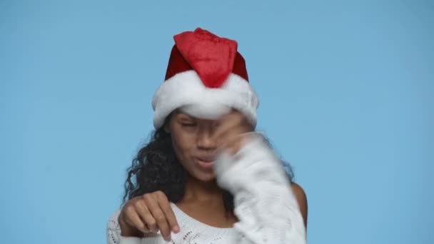 楽しいです幸せなアフリカ系アメリカ人女性でサンタ帽子ダンス孤立オンブルー — ストック動画