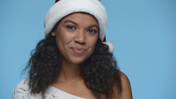 笑着梦想着的非洲裔美国女人 戴着圣诞帽 孤身一人蓝色 — 图库视频影像