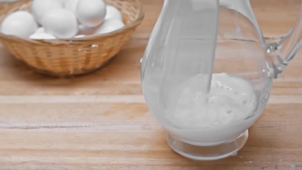 Movimiento Lento Leche Vertiendo Jarra Cerca Los Huevos Cesta Mimbre — Vídeo de stock