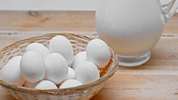 Αυγά Καλάθι Και Κανάτα Γάλακτος Ξύλινη Επιφάνεια Που Απομονώνονται Γκρι — Αρχείο Βίντεο