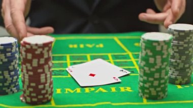 Poker çiplerinin yakınına iskambil kağıtları atan oyuncuların yavaş çekimleri