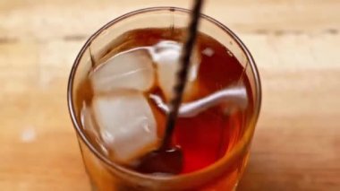 Bardakta viski ve buz karışımı kokteyl kaşığı.