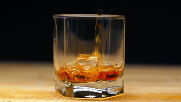 Rallentatore Whisky Versato Nel Bicchiere Con Cubetto Ghiaccio Isolato Sul — Video Stock