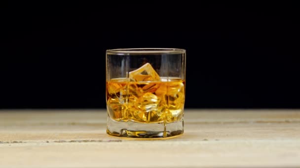 Üveg Whisky Jégkockákkal Asztalon Elszigetelt Fekete — Stock videók