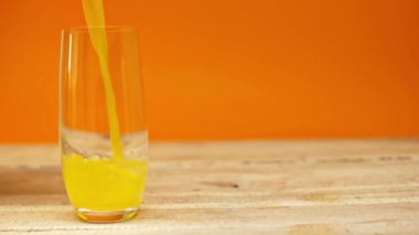 Portakal suyunun ağır çekimde portakallı ahşap masaya dökülmesi.