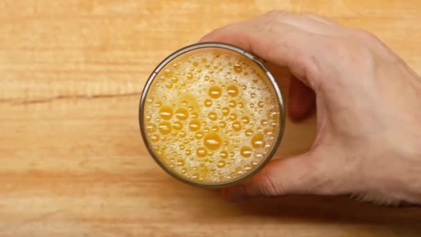 木製の表面にオレンジジュースのガラスを取って男のスローモーション — ストック動画