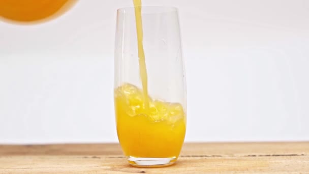 Movimento Lento Suco Laranja Derramando Vidro Superfície Madeira Isolada Branco — Vídeo de Stock