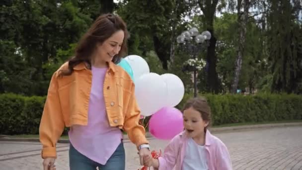 Schattig Kind Praten Hand Hand Met Moeder Buurt Ballonnen Park — Stockvideo