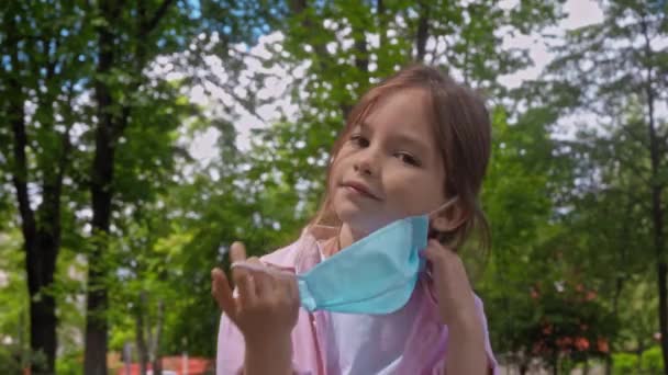 Criança Feliz Tirando Máscara Médica Alongamento Parque — Vídeo de Stock