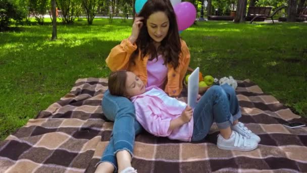Boldog Gyerek Fekvő Közelében Vonzó Anya Digitális Tabletta Parkban — Stock videók