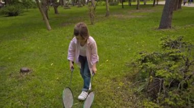 tapılası çocuk yeşil çimlerde badminton oynuyor 