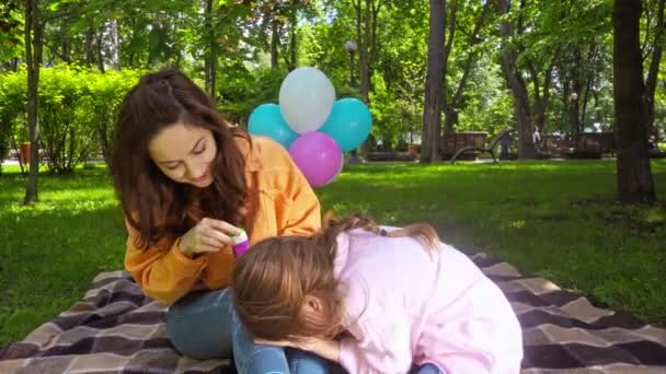 Güzel Bir Anne Piknikte Tatlı Kızının Yanında Sabun Köpüğü Üflüyor — Stok video