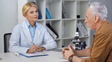 Doktor hasta dinliyor ve reçete yazıyor. 