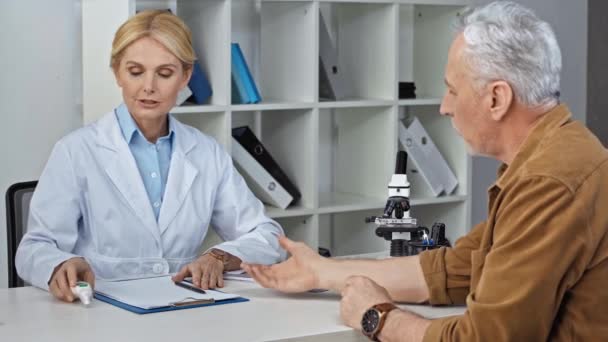 Μεσήλικας Γιατρός Που Χρησιμοποιεί Πυρόμετρο Στον Άνθρωπο Και Γράφει Διάγνωση — Αρχείο Βίντεο