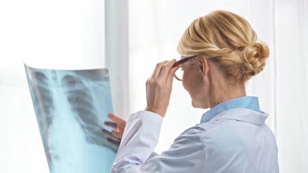 Dokter Van Middelbare Leeftijd Draagt Een Bril Kijkt Naar Röntgenfoto — Stockvideo