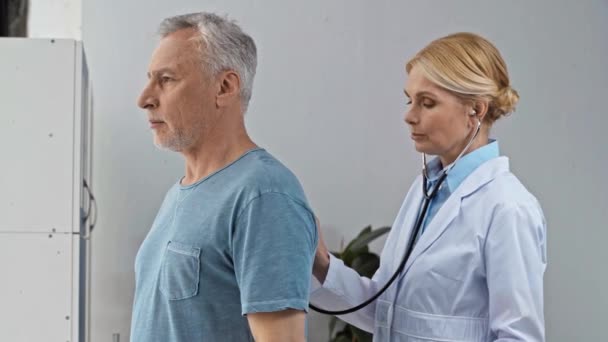 Arzt Mittleren Alters Untersucht Mann Klinik — Stockvideo