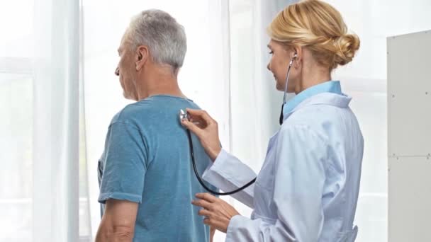 Μεσήλικας Γιατρός Λευκό Παλτό Εξετάζει Ώριμο Άνθρωπο Στην Κλινική — Αρχείο Βίντεο